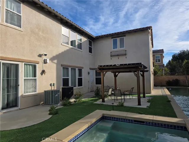 a view of a house with backyard sitting area and garden