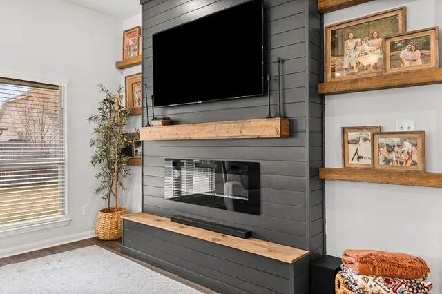 a living room filled with furniture and kitchen view