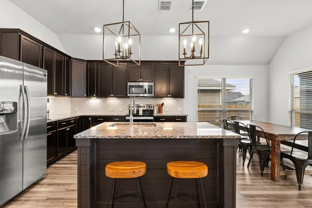 a kitchen with granite countertop a sink stove and wooden floor
