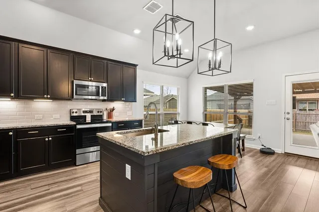 a kitchen with granite countertop a sink and a microwave