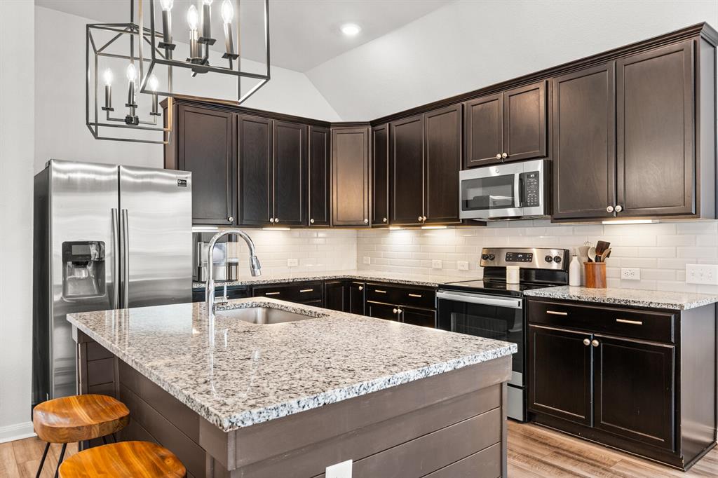 10237 Omni Drive Waco, TX 76708 - Photo 27 of 40 a kitchen with granite countertop a sink a stove and refrigerator