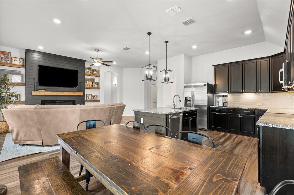 10237 Omni Drive Waco, TX 76708 - Photo 30 of 40 a large kitchen with kitchen island a stove a sink a oven and a dining table with wooden floor