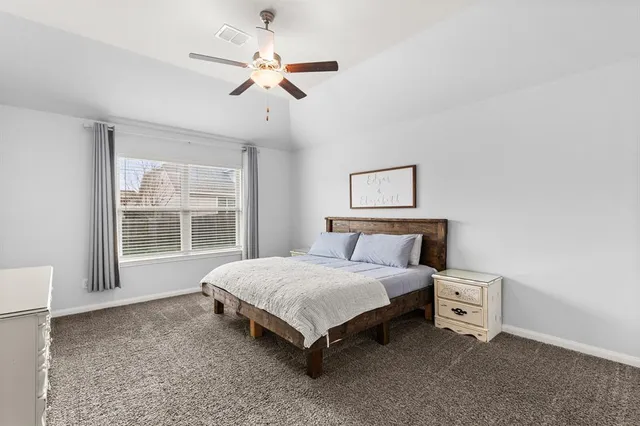 a bedroom with a large bed and a flat screen tv