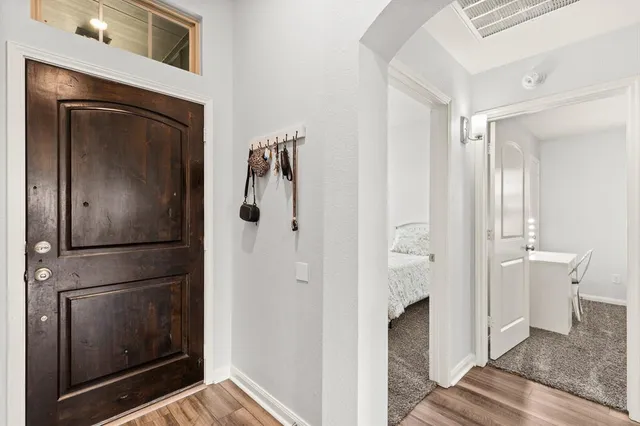 a view of a hallway with wooden floor and staircase