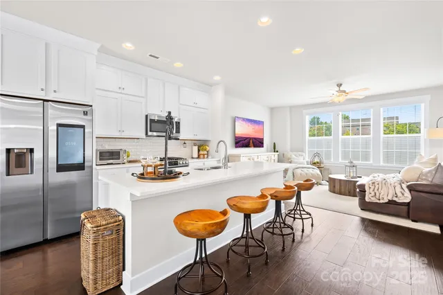 a living room with stainless steel appliances furniture a couch and a window