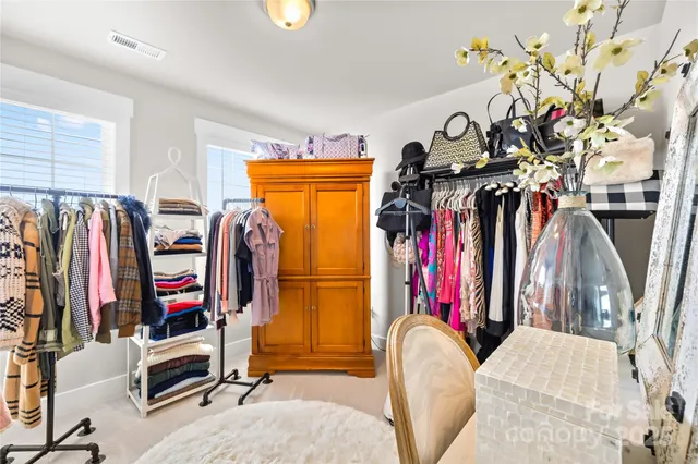 a view of walk in closet with clothes and shoes