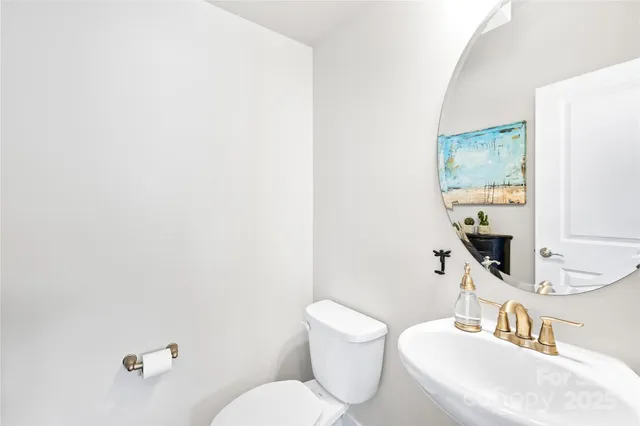 a bathroom with a toilet a sink and mirror