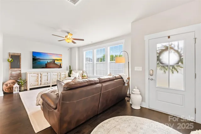 a living room with furniture a flat screen tv and a floor to ceiling window