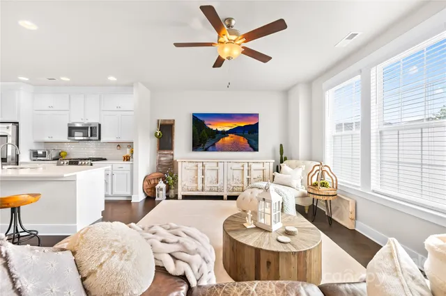 a living room with stainless steel appliances kitchen island granite countertop furniture and a large window