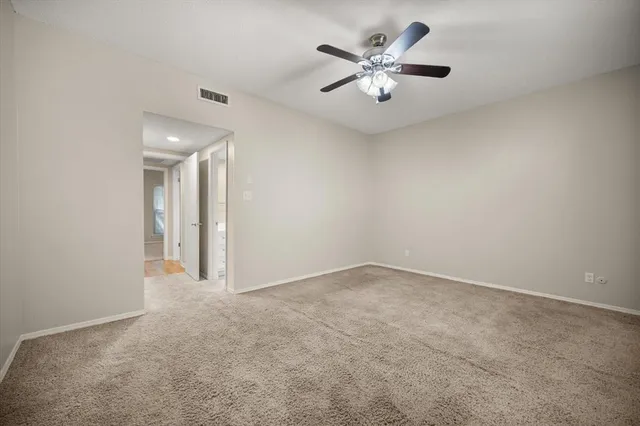 an empty room with closet and fan
