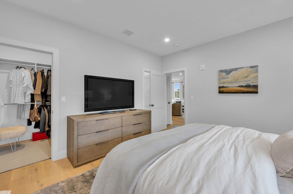 5245 Washington Street, Unit 5 Boston, MA 02132 - Photo 18 of 37 a bedroom with a bed and a flat screen tv