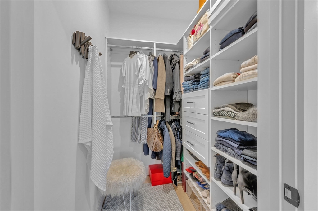 5245 Washington Street, Unit 5 Boston, MA 02132 - Photo 21 of 37 a walk in closet with clothes and shoes