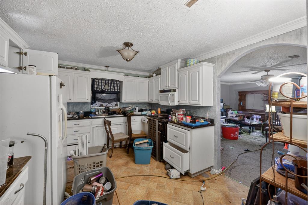 801 North Main Street Dodd City, TX 75438 - Photo 17 of 31 a kitchen with a refrigerator a stove and white cabinets
