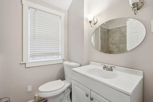 a bathroom with a toilet a sink and mirror