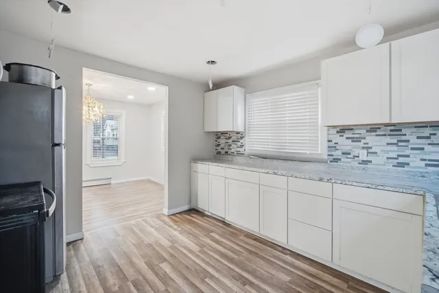 a kitchen with granite countertop a stove a sink and a refrigerator
