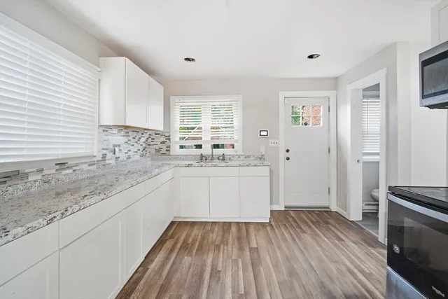 a kitchen with a sink wooden floor and white appliances