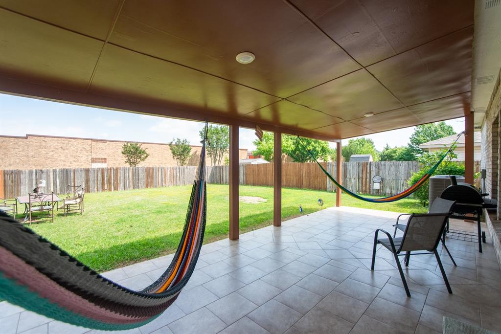 5718 Green Ivy Road Denton, TX 76210 - Photo 3 of 37 Covered patio with recessed lighting, supported by columns, featuring tile flooring and an expansive green lawn