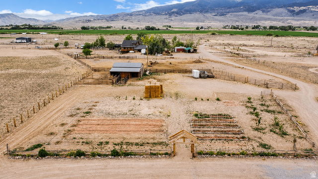 544 East 600 North, Unit 1 Joseph, UT 84739 - Photo 65 of 65 Expansive rural property featuring a large garden area with raised beds, a wooden garden archway, a barn structure with a metal roof, extensive fencing, and distant mountain backdrops