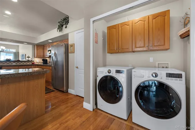 a view of a kitchen with stainless steel appliances granite countertop a refrigerator a sink dishwasher and wooden cabinets with wooden floor