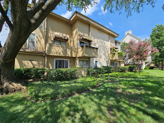 a front view of a residential apartment building with a yard