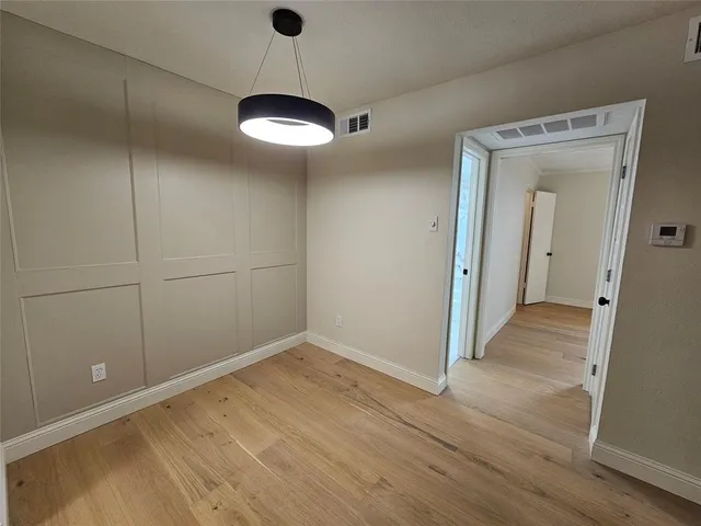 a view of a room with wooden floor and a ceiling fan