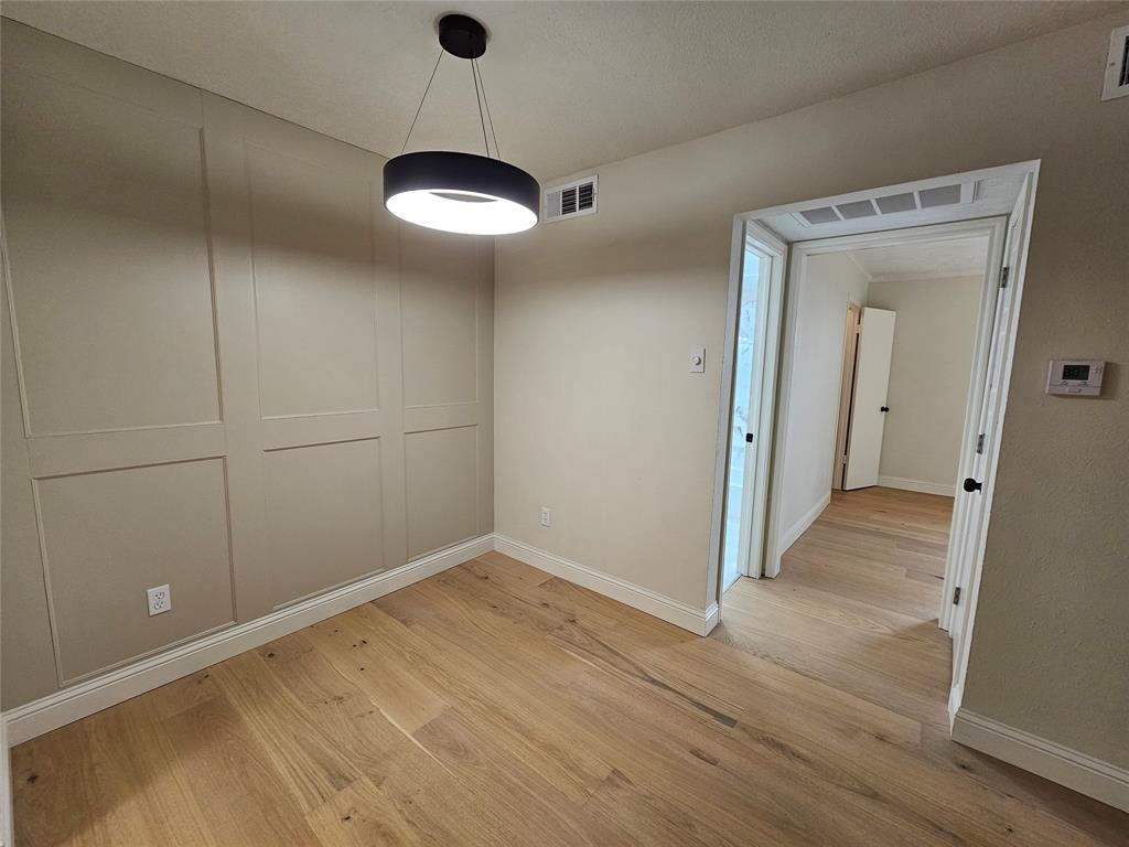 4327 Holland Avenue, Unit 102 Dallas, TX 75219 - Photo 12 of 20 a view of a room with wooden floor and a ceiling fan