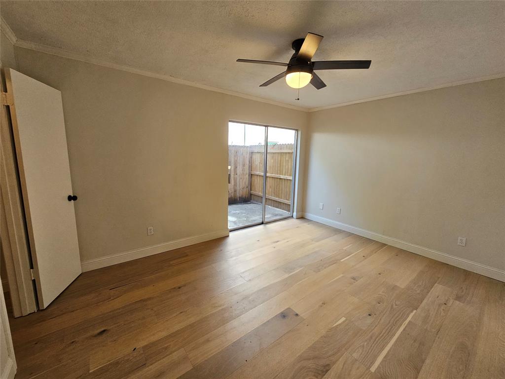 4327 Holland Avenue, Unit 102 Dallas, TX 75219 - Photo 16 of 20 an empty room with wooden floor and windows