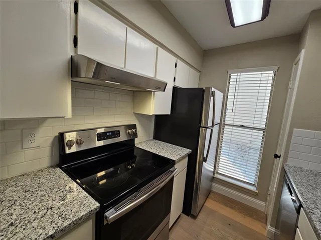a kitchen with stainless steel appliances granite countertop a refrigerator and a stove