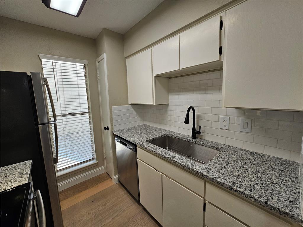 4327 Holland Avenue, Unit 102 Dallas, TX 75219 - Photo 6 of 20 a kitchen with granite countertop a sink stainless steel appliances and cabinets