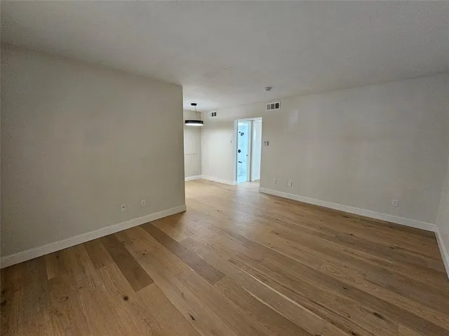 a view of an empty room and wooden floor
