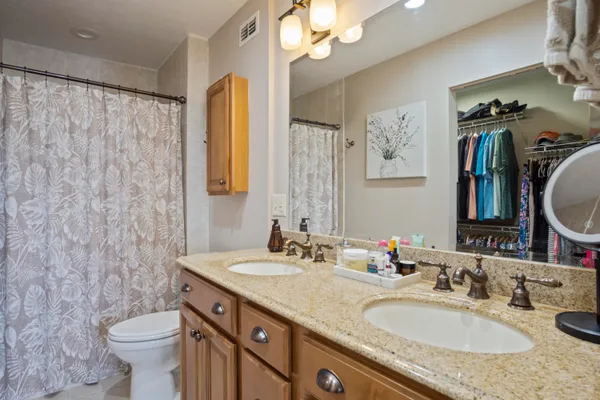 a bathroom with a granite countertop sink toilet and a mirror