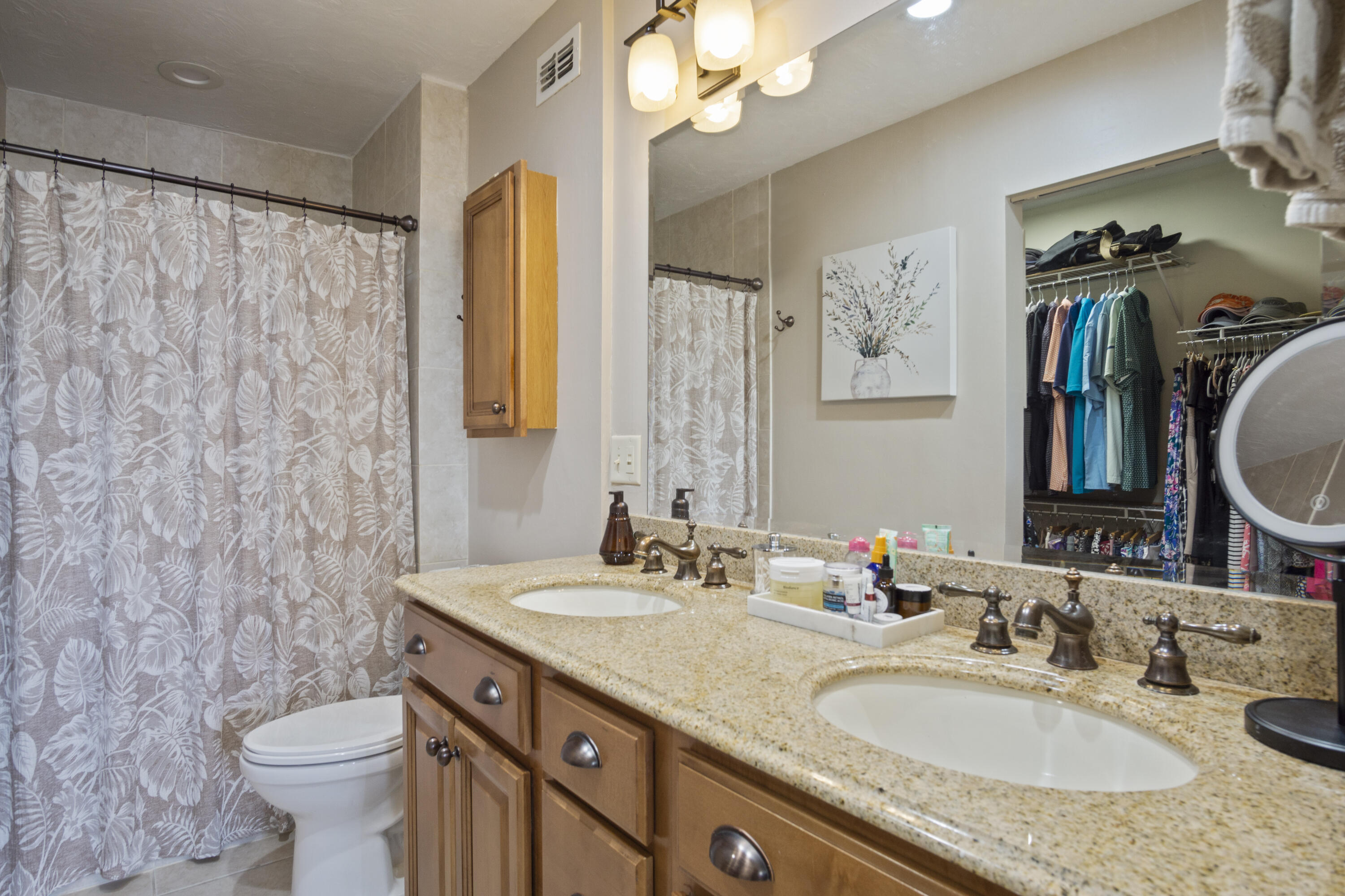 5335 Southeast Miles Grant Road, Unit H 209 Stuart, FL 34997 - Photo 15 of 26 a bathroom with a granite countertop sink toilet and a mirror
