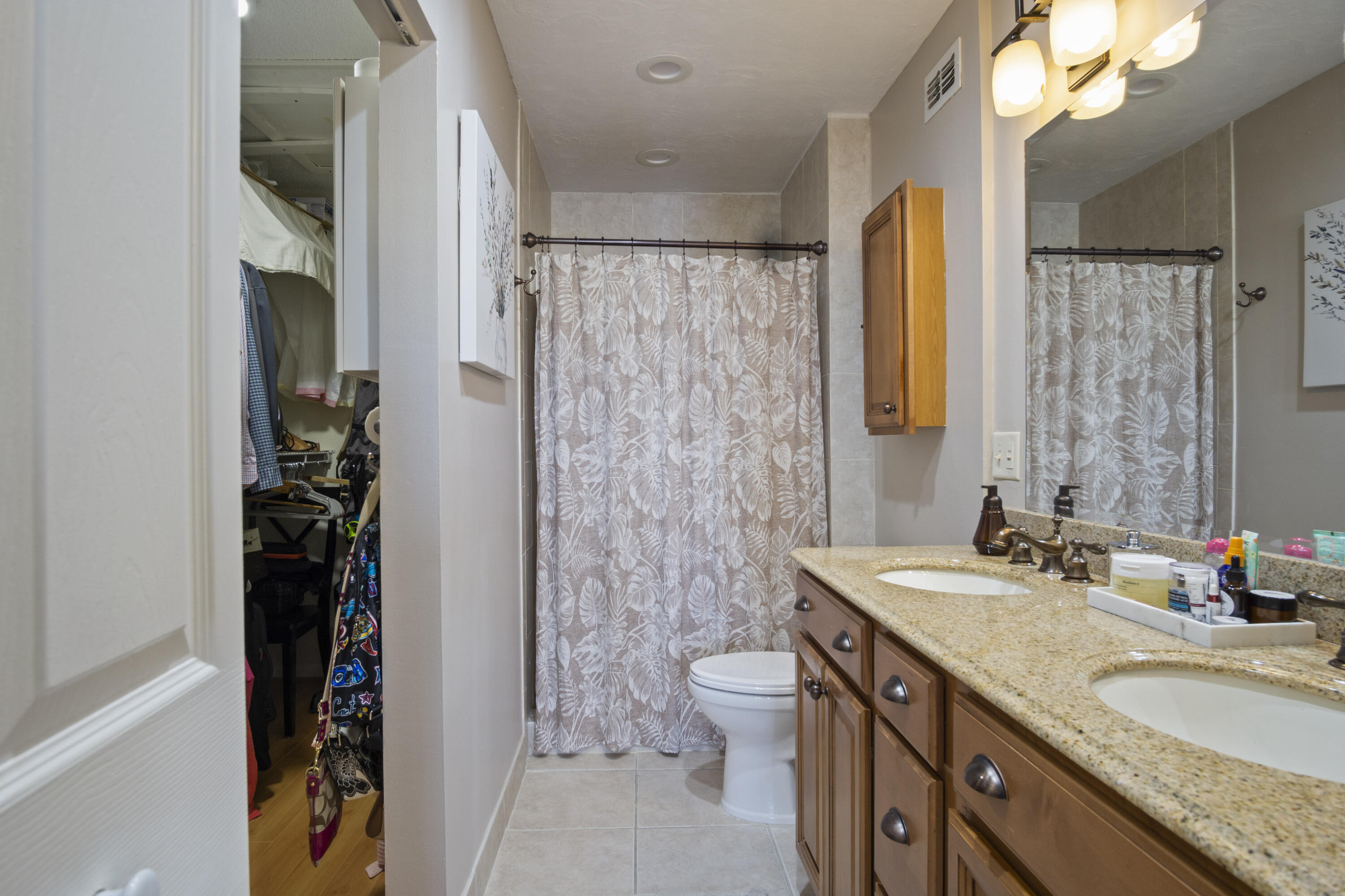 5335 Southeast Miles Grant Road, Unit H 209 Stuart, FL 34997 - Photo 16 of 26 a bathroom with a granite countertop sink toilet and shower