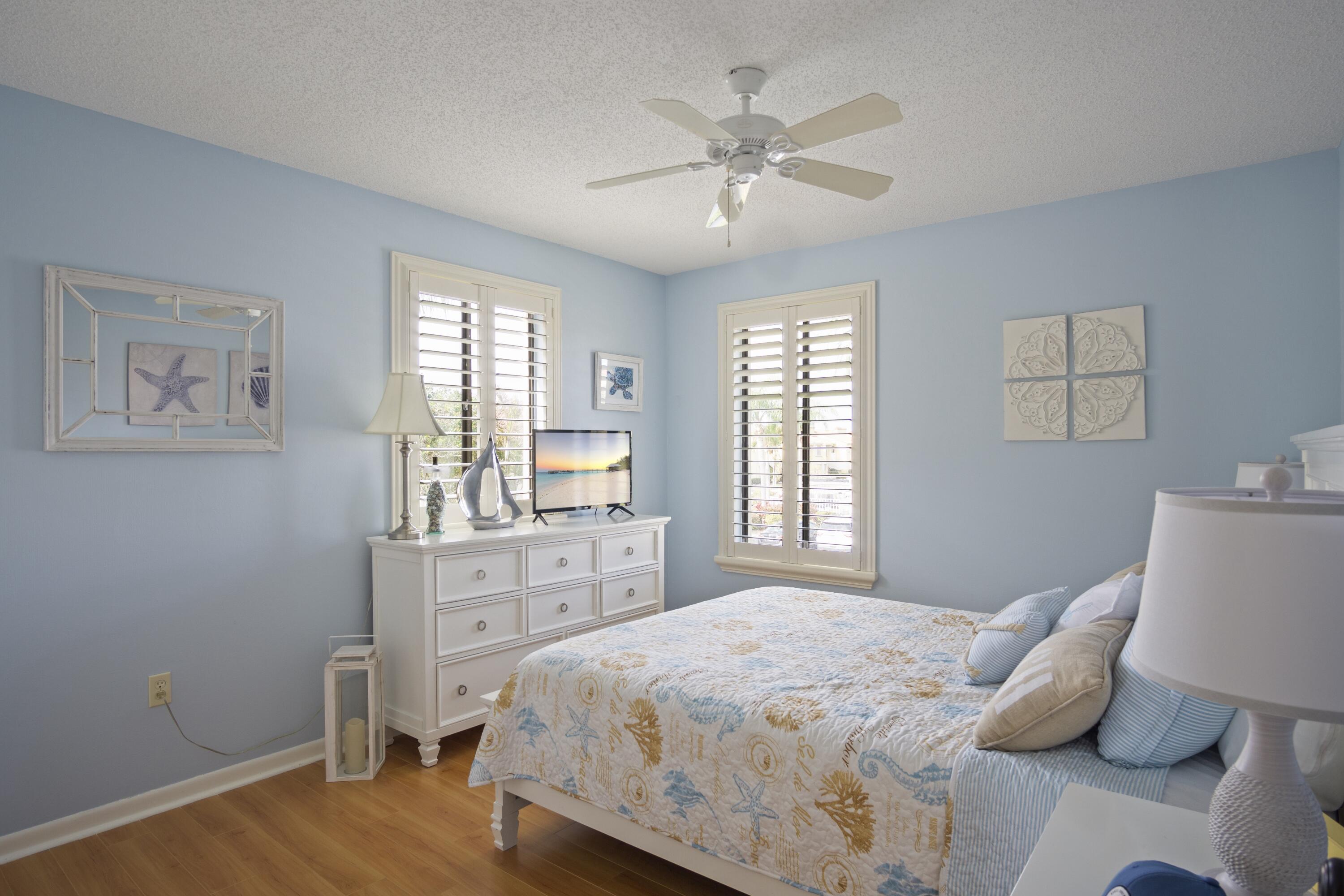 5335 Southeast Miles Grant Road, Unit H 209 Stuart, FL 34997 - Photo 18 of 26 a bedroom with a bed and a chandelier