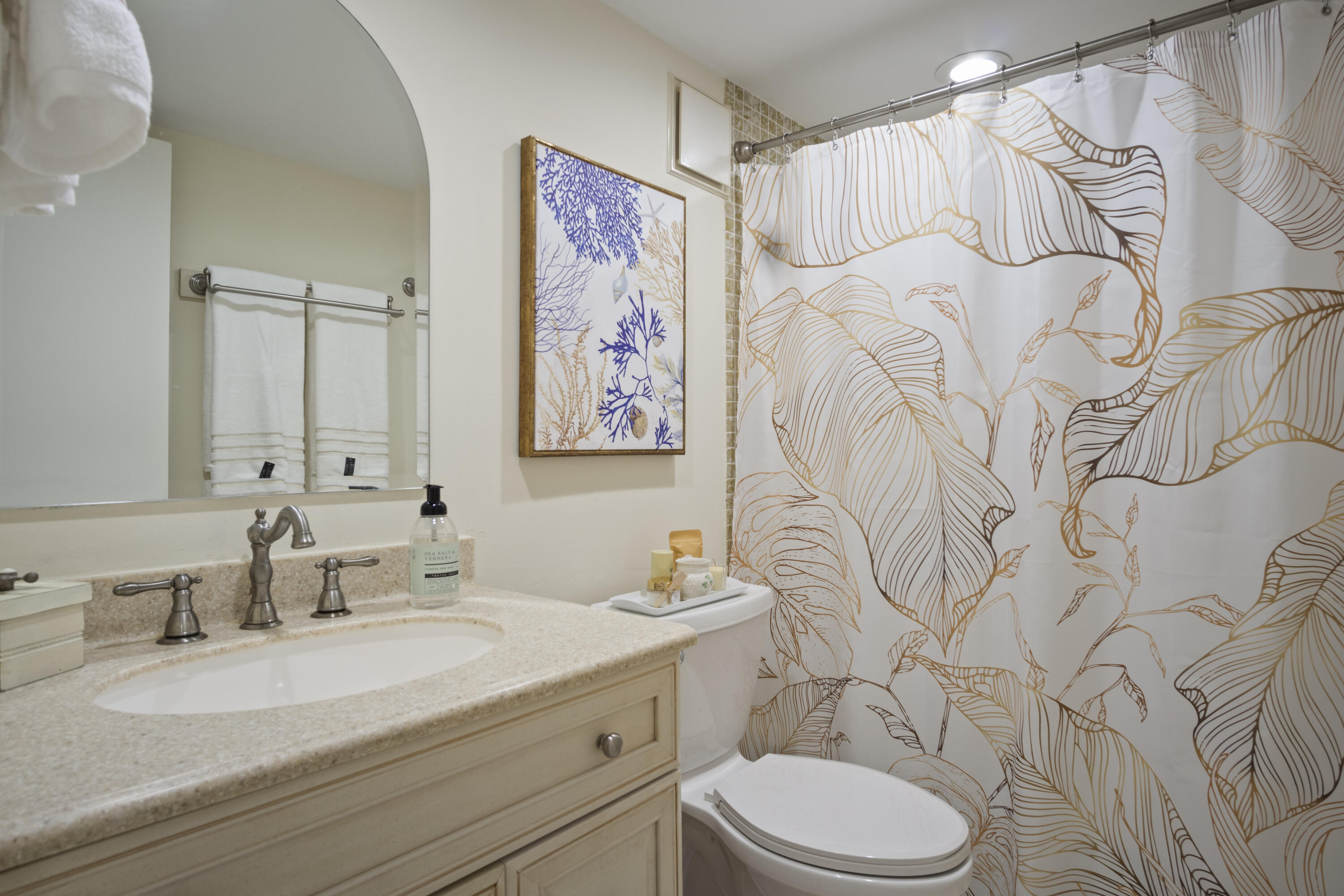 5335 Southeast Miles Grant Road, Unit H 209 Stuart, FL 34997 - Photo 19 of 26 a bathroom with a granite countertop toilet sink mirror vanity and shower
