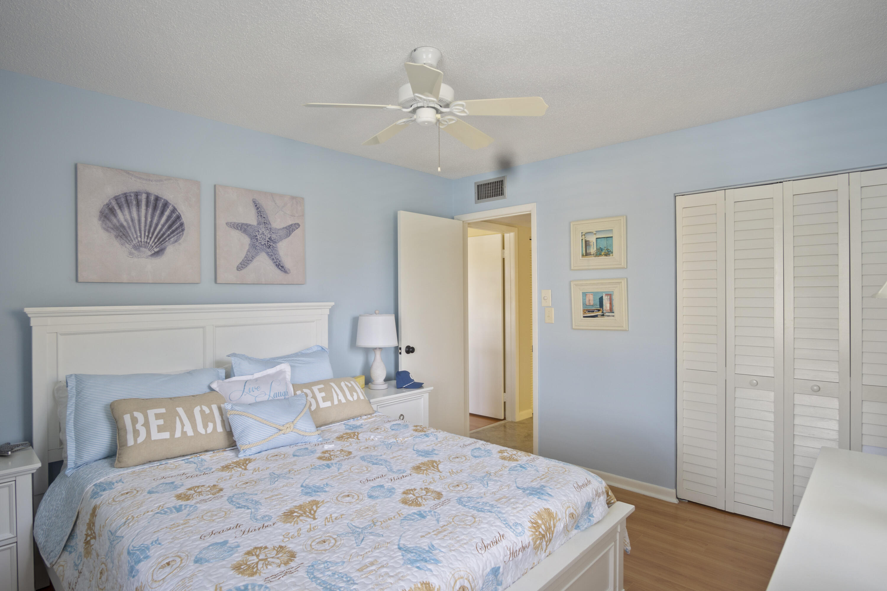 5335 Southeast Miles Grant Road, Unit H 209 Stuart, FL 34997 - Photo 20 of 26 a bedroom with a large bed and a chandelier