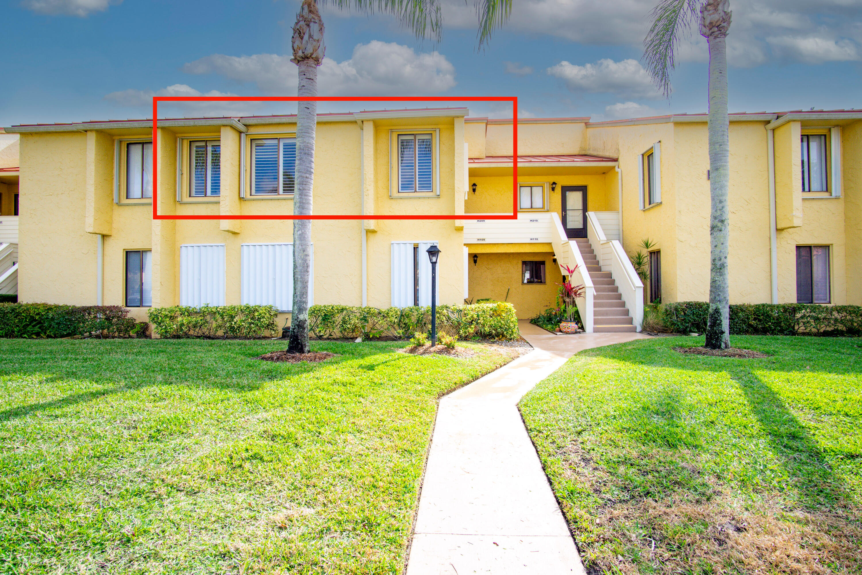 5335 Southeast Miles Grant Road, Unit H 209 Stuart, FL 34997 - Photo 2 of 26 a front view of a house with a yard