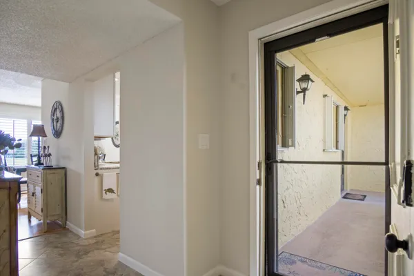 a view of a hallway with kitchen and refrigerator