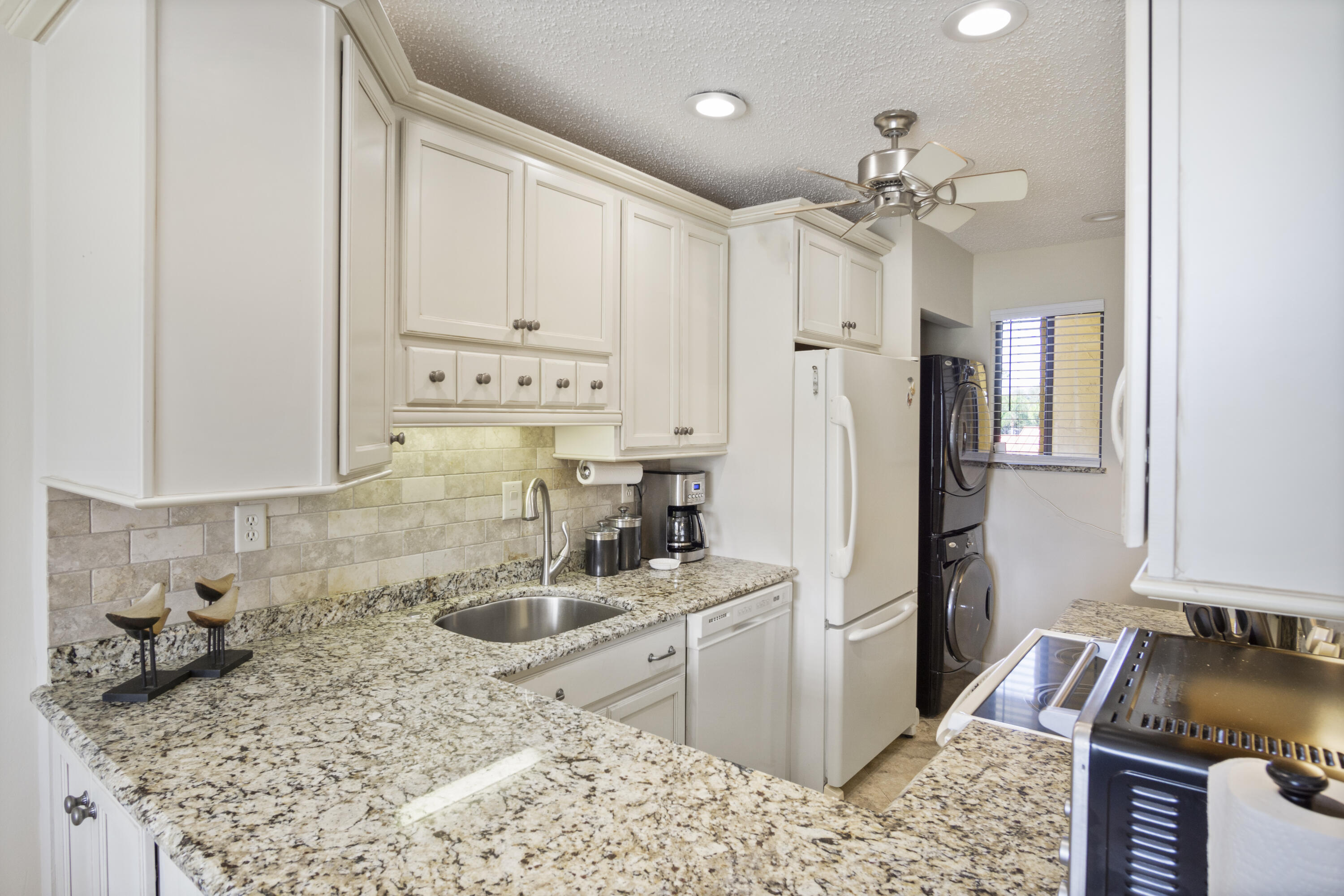 5335 Southeast Miles Grant Road, Unit H 209 Stuart, FL 34997 - Photo 3 of 26 a kitchen with stainless steel appliances granite countertop a sink stove and refrigerator
