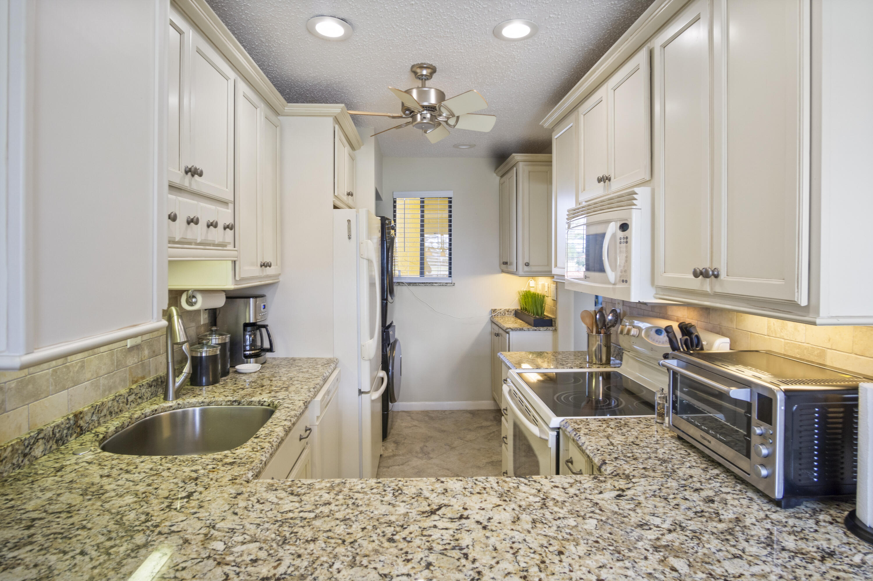 5335 Southeast Miles Grant Road, Unit H 209 Stuart, FL 34997 - Photo 4 of 26 a kitchen with stainless steel appliances granite countertop a sink and a granite counter tops