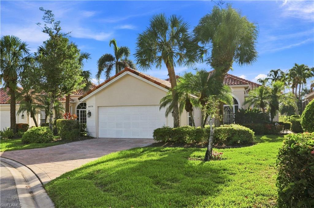 4470 Novato Court Naples, FL 34109 - Photo 1 of 33 Mediterranean-style architecture with a tile roof, stucco exterior, and an arched entry with decorative ironwork