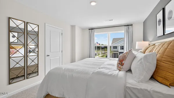 a large bed sitting in a bedroom next to a window