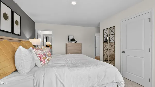 a bedroom with a large bed and a chair