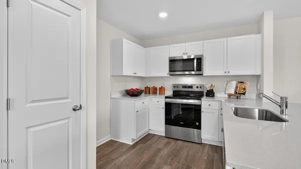 a kitchen with granite countertop white cabinets and stainless steel appliances
