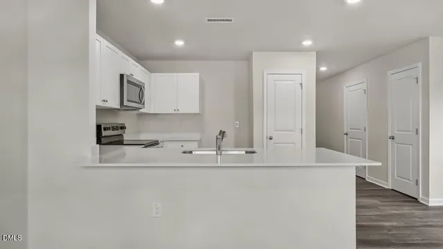 a view of kitchen with stainless steel appliances granite countertop refrigerator sink and stove