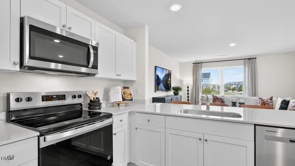 a kitchen with stainless steel appliances a stove a microwave a sink and cabinets