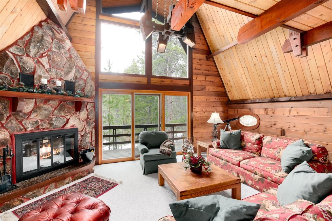 522 Wellington Road Breckenridge, CO 80424 - Photo 9 of 43 a living room with furniture a fireplace and a floor to ceiling window