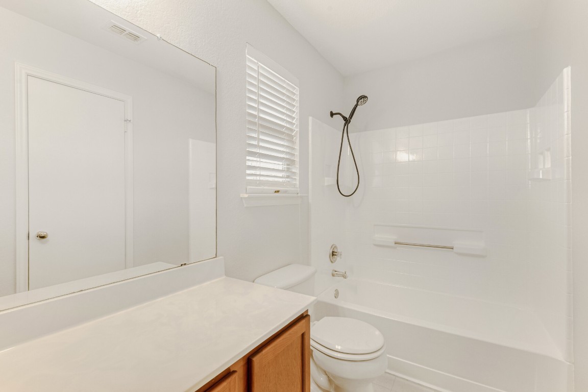 4010 Reeders Drive Austin, TX 78725 - Photo 26 of 26 Full bathroom featuring washtub / shower combination, vanity, and light tile patterned floors