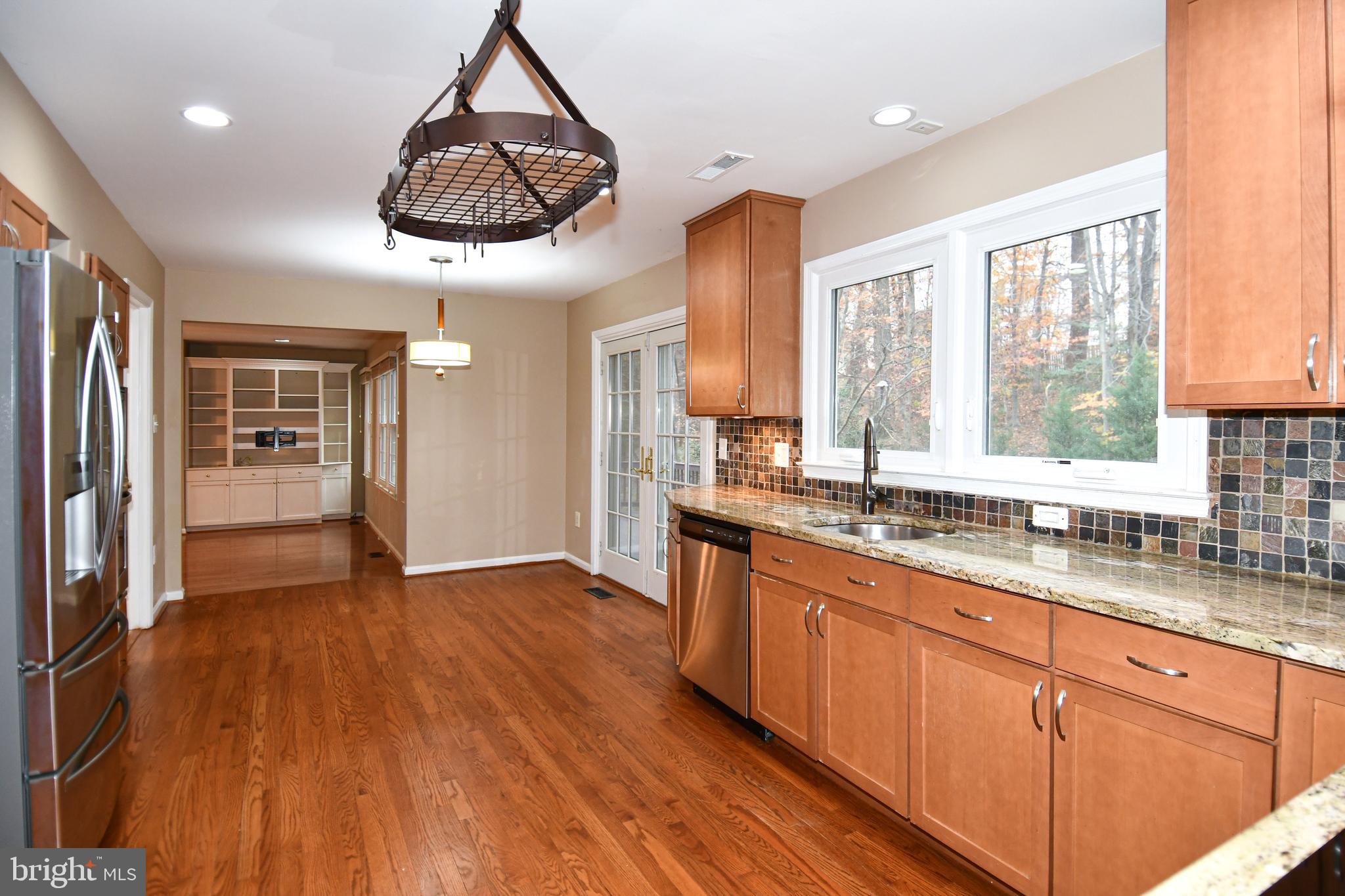 13135 Hutchinson Way Silver Spring, MD 20906 - Photo 16 of 64 a kitchen with stainless steel appliances granite countertop wooden floors and wide window
