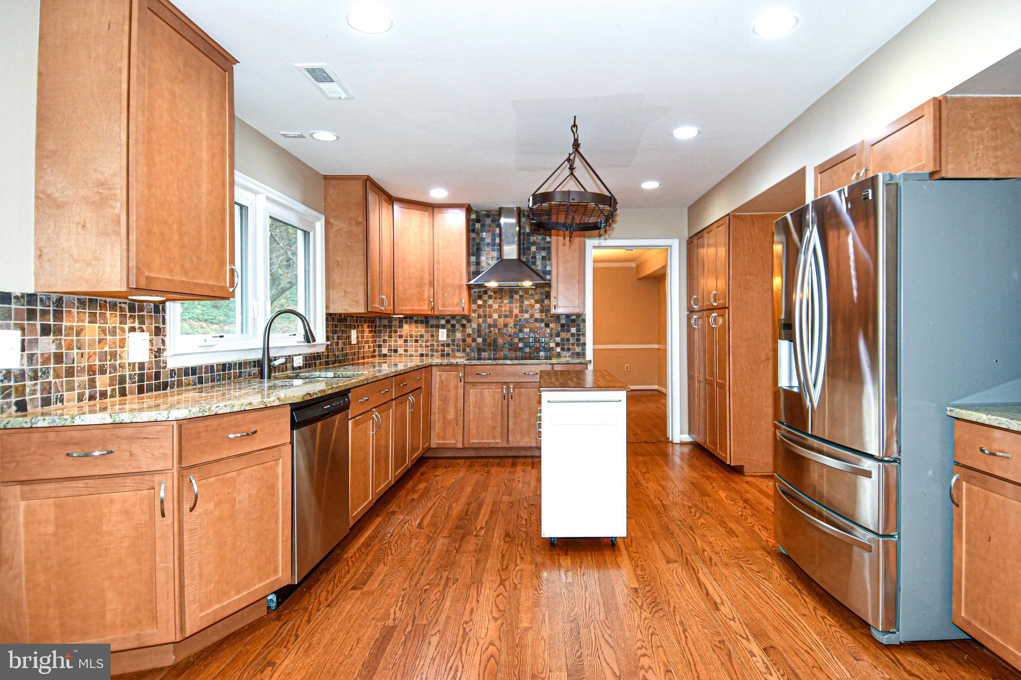 13135 Hutchinson Way Silver Spring, MD 20906 - Photo 19 of 64 a kitchen with stainless steel appliances granite countertop a refrigerator a sink dishwasher a stove and white countertops with wooden floor